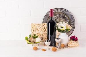 hermosa todavía vida para el primavera fiesta de judío Pascua. frente ver de tradicional productos para día festivo, matzot, botella de rojo vino, plato. foto