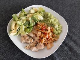 Homemade grilled chicken cooked zucchini, green salad, sliced avocado and Kimchi photo