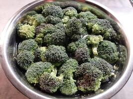 Raw broccoli chopped on a metal bowl. Healthy vegetables. photo