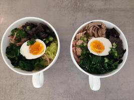 Asian ramen soba noodle soup close up with chicken, boiled egg, nori, green spinach and green onion .Top view photo