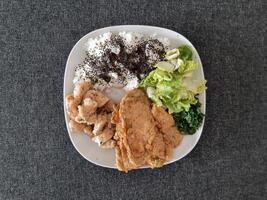 Homemade grilled chicken with grilled zucchini, green salad, spring rolls, rice pilaf and parsley. Broccoli seeds on top of the rice pilaf. photo