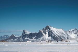 Scandinavian house in mountain range and blue sky on winter at Lofoten photo