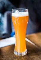 Yellow draft beer with foam in glass photo