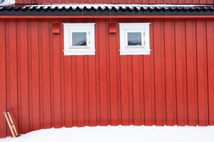 rojo pescar casa con blanco ventana y nieve o rorbuer en Escandinavia foto