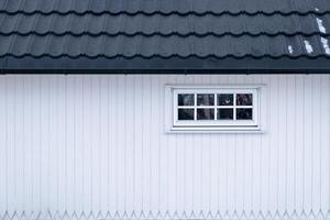 White wooden house with window and tile roof photo