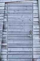 Envejecido de madera gris puerta de el cabaña en travesía foto