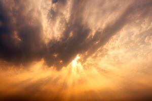 Dramatic golden sky with sunbeam and light rays in the sunset photo