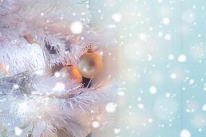 White Christmas tree with golden balls and snow glittering photo