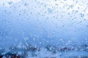 Abstract blue icy snowflake on window in winter season on christmas festive photo