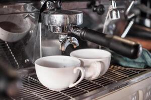 Coffee Maker making coffee flowing in cup photo