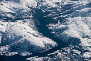 Aerial view of snowy mountain range with lake on winter photo