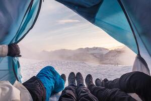 Group of climber are inside a tent with open for view of blizzard on mountain photo