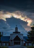 Mysterious cloud iridescence phenomenon glowing over christian church in the evening photo