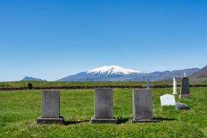 lápida sepulcral en césped en cristiano Iglesia cementerio en verano a Islandia foto