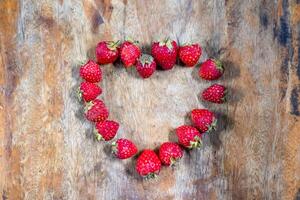 Strawberry heart shape design on wooden table - Concept Valentine Day photo