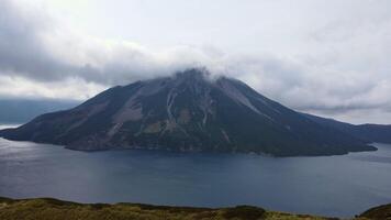 aérien vue de le Krénitsyne volcan sur Onecotan île. Montagne Haut dans le des nuages video