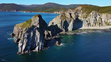 Aerial. cape with high cliffs on a sunny day by the sea. Mountain ridges video