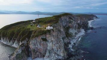 Aerial view of the old Balyuzek lighthouse on the rocky coast of the sea video