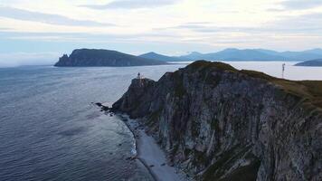 Aerial view of the old Balyuzek lighthouse on the rocky coast of the sea video