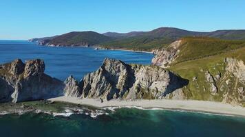 Aerial. cape with high cliffs on a sunny day by the sea. Mountain ridges video