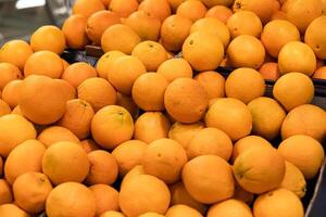 Orange fruit pile on stall in supermarket photo