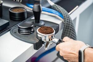 Barista holding portafilter with ground coffee photo