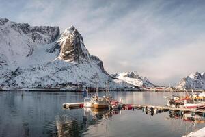 Fishing boat at harbour with snowy mountain photo