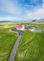 Holy Ingjaldsholskirkja church on hill among the meadow and foggy in summer at Snaefellsnes peninsula, Iceland photo