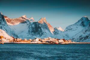 Winter wonderland of Reine town fishing village with fjord mountain in the morning at Lofoten Islands photo