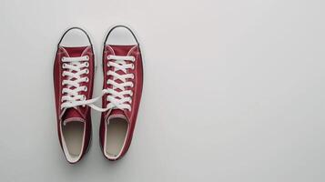 AI generated Maroon canvas shoes isolated on flat white background with copy space for advertisement. Generative AI photo