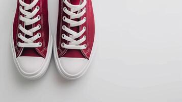 AI generated Maroon canvas shoes isolated on flat white background with copy space for advertisement. Generative AI photo