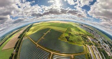 abstract circular curvature of surface of earth and twisting of sky over on farm field of solar panels video