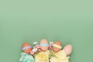 Decorated eggs with flowers on empty background. Fun Easter background photo