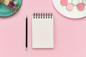Blank notebook and pencil on pink background with pink candles and smudge stick photo