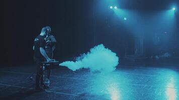 A stage worker fills the smoke scenes from the smoke machine. Preparation for a concert or performance. Life behind the scenes. video