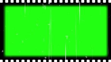 Film frame texture with sprocket hole on green screen with grain, film dirt, dust, hair, leaks and scratches. Old Film reel strip rolling overlay. 4k resolution free video download