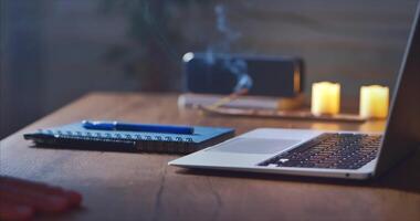 Home Office. A man takes a notebook with a pen, a music column, an incense stick video