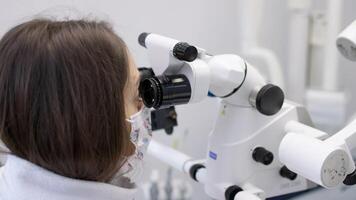 Woman Dental Surgeon Examining Teeth Of Patient Using Operating Microscope. High quality 4k footage video