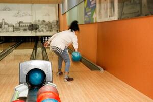 woman playing bowling, rear view photo