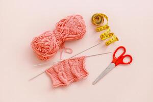 knitting and a skein of thread, scissors and a measuring tape photo