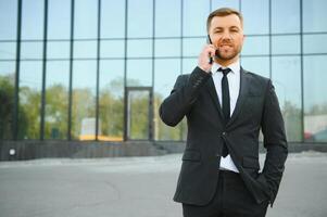 Businessman using smartphone in covered walkway. photo