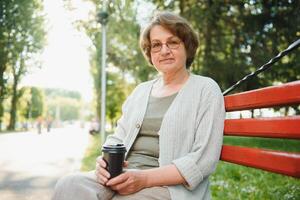 Portrait of a happy Senior woman in summer park photo