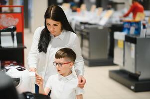 Happy mother with son in home appliance store. photo