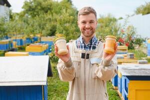 Beekeeper on apiary. Beekeeper is working with bees and beehives on the apiary. photo