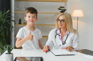 cuidado de la salud para niños pequeño chico hablando a médico durante visitar a hospital. foto