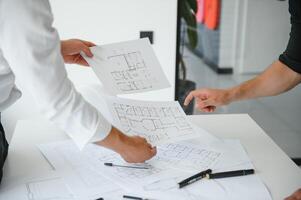ingeniero o arquitecto trabajo en equipo trabajando en construcción proyecto con edificio modelo y Plano en oficina. construcción concepto. foto