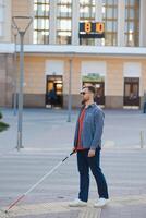 Blind man. People with disability, handicapped person and everyday life. Visually impaired man with walking stick. photo