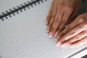 Blind woman read book written in Braille. Close up finger touch to braille Code photo