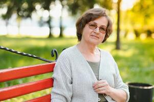 Senior woman walking in the park in summer. photo