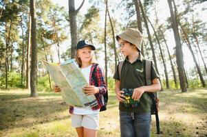 chico y niña Vamos excursionismo con mochilas en bosque la carretera brillante soleado día foto